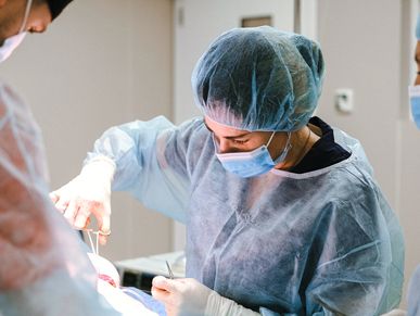 A woman PA working in the operating room.