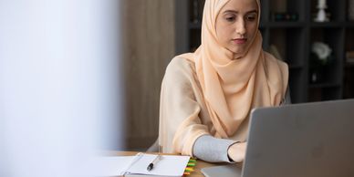 Women wearing a hijab working on the laptop