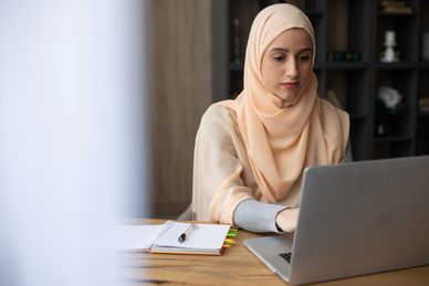 Hijabi working on a laptop
