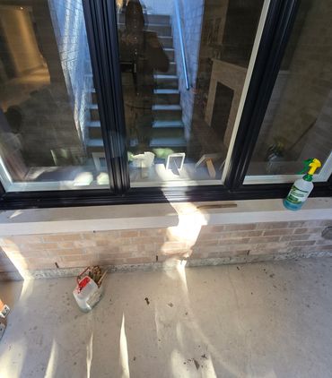 Black silicone sealant applied to window frame.