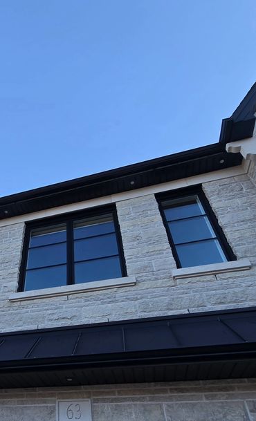 Black silicone applied around window to stone substrate.