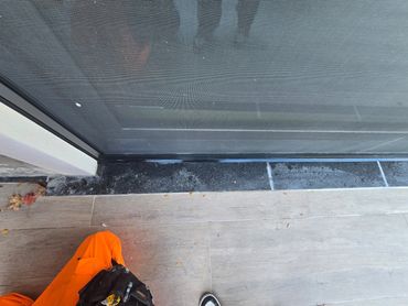 Caulking sliding door perimeter.