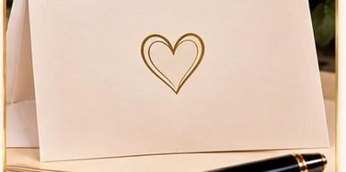Elegant card with a gold heart and pen.