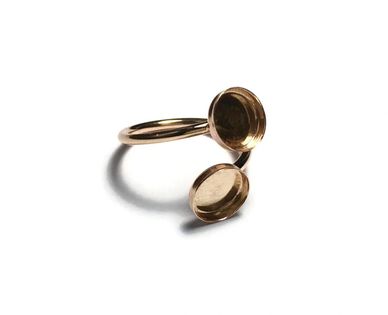 A gold ring with an open locket design on a white background.