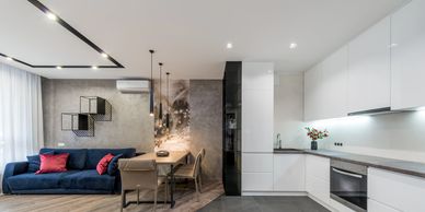 Modern open-plan kitchen and living room with minimalist design and cozy dining area.