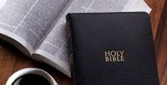 A closed Holy Bible with an open Bible and coffee.