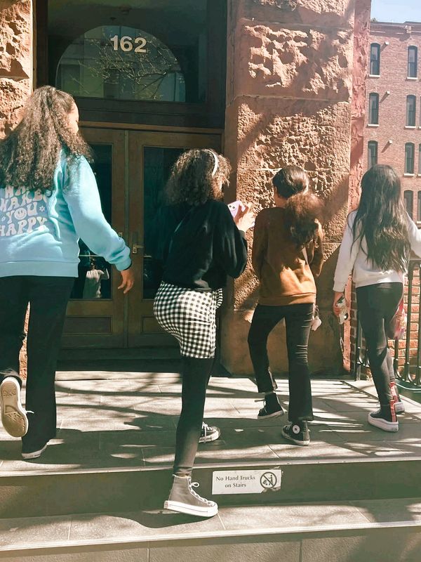 Four confident girls walk side by side, their expressions radiating determination and strength. 