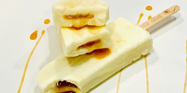 Creamy ice cream bars with caramel filling on a white plate.