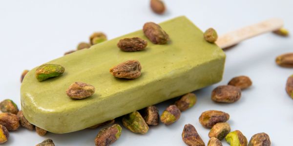 Green pistachio ice cream bar with pistachio nuts.