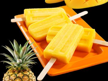 Four yellow popsicles on an orange tray with a pineapple.