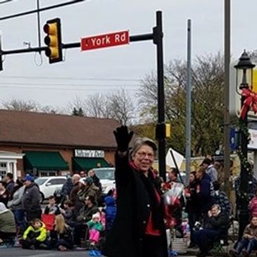 This is a photo of Nancy smiling and waving while walking in a holiday parade in Hatboro, PA.