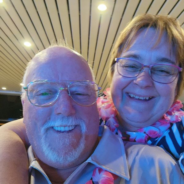 Happy cruisers dressed in leis and having fun during Hawaiian Night on a Carnival ship.