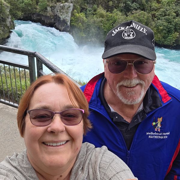Visitors enjoying the scenic lookout over Huka Falls’ bright blue rushing water in New Zealand