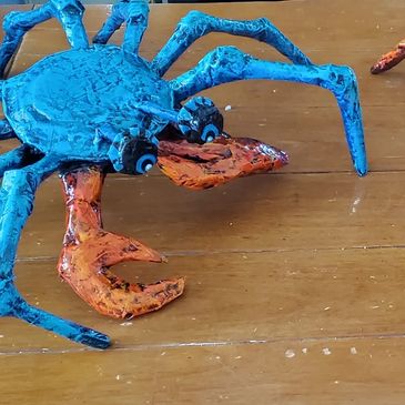 A colorful crab sculpture on a wooden surface.