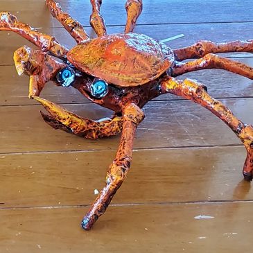 A colorful crab sculpture on a wooden surface.