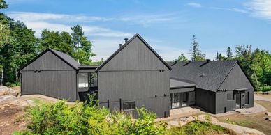 Maison moderne noire dans un cadre naturel.