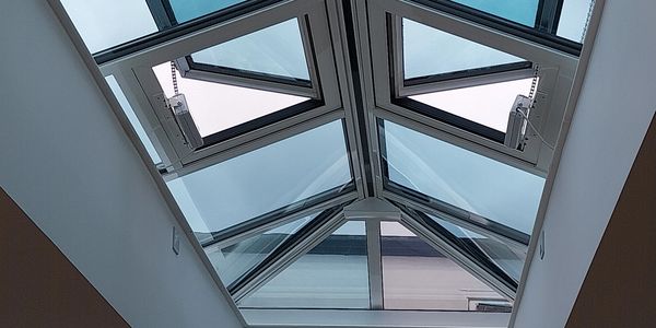 Modern glass skylight with openable triangular windows.