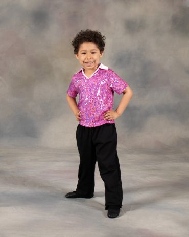 Smiling child in a sparkly purple shirt and black pants.