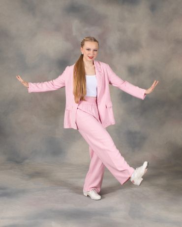 Woman in pink suit dancing.