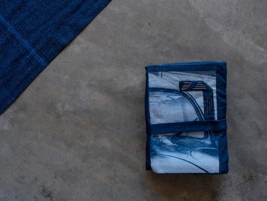 Tissu bleu plié sur sol gris.