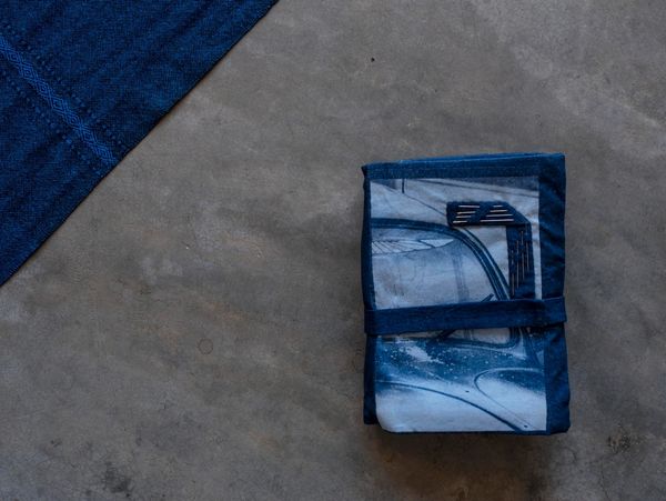 Tissu bleu plié sur sol gris.