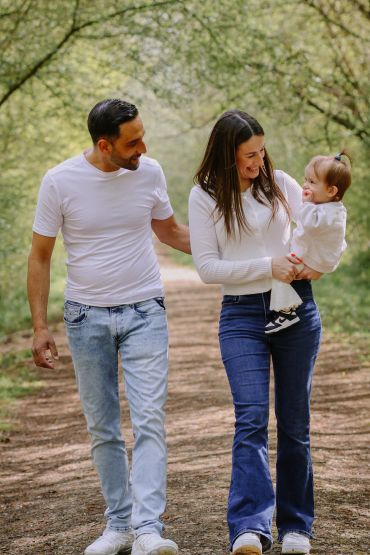 A happy family walking outdoors on a sunny day.
