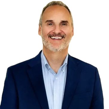 Man in a blue blazer smiling against a white background.