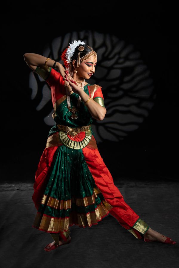 A classical Indian dancer in vibrant traditional attire striking a graceful pose.
