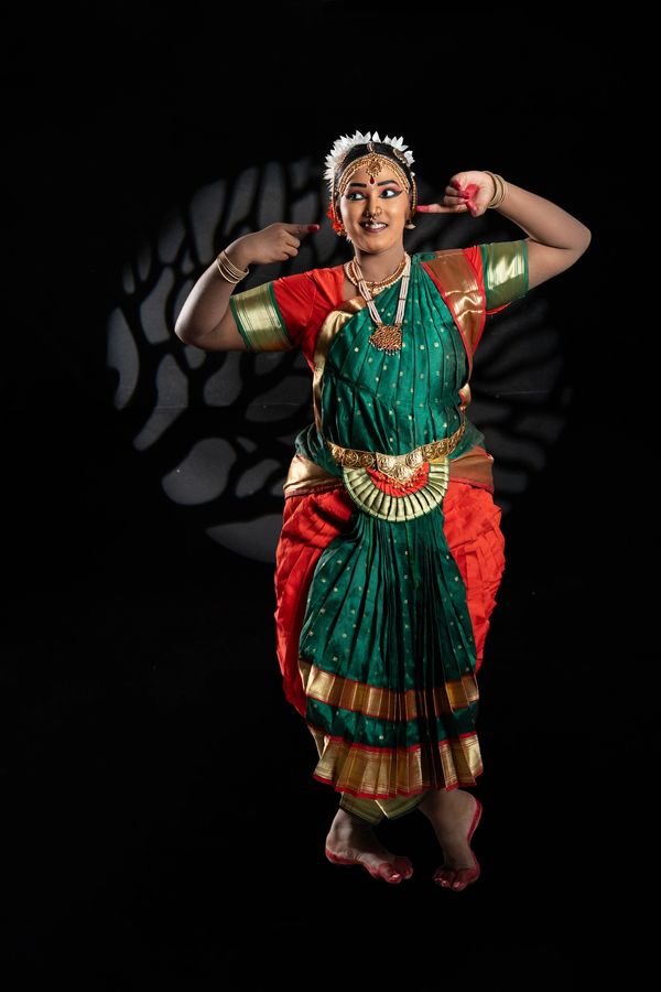 A classical Indian dancer in traditional costume striking a pose.