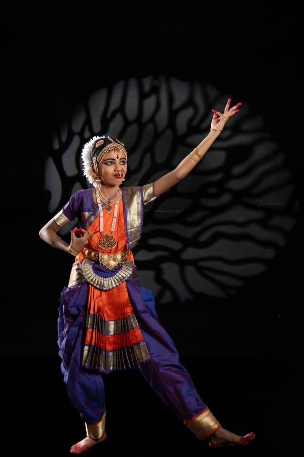 Young dancer performing traditional Indian classical dance in vibrant costume.