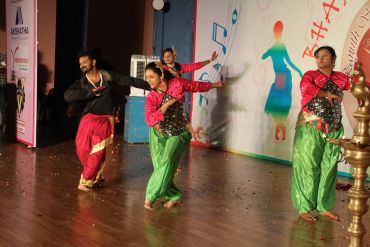 Dancers performing on stage in colorful traditional attire.