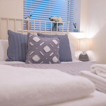 Cosy bed with stylish cushions and fluffy towels.