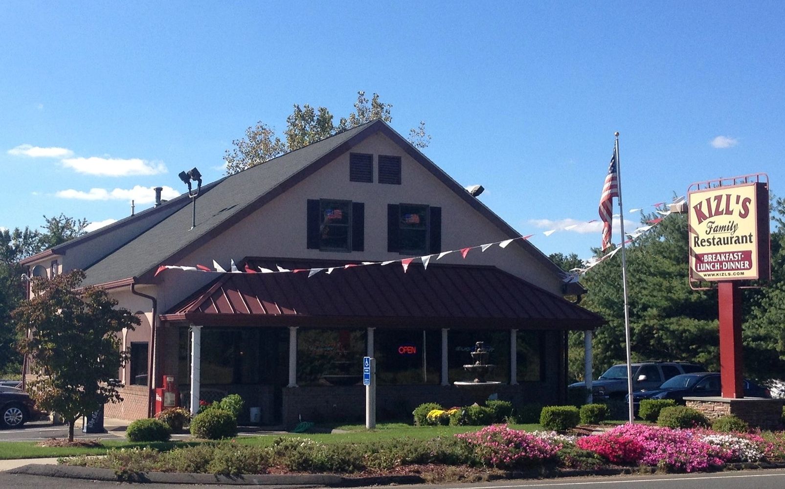 Kizl's Family Restaurant with outdoor landscaping and an American flag.