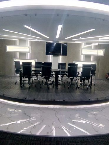 Modern conference room with sleek chairs and a large screen.