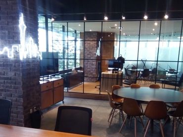 Modern office space with glass partitions and a round meeting table.