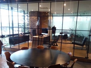 Modern office meeting room with a round table and glass walls.