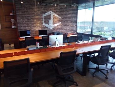 Modern office space with multiple computer workstations and ergonomic chairs.