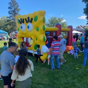 Children enjoying a SpongeBob-themed bounce house at an outdoor event.