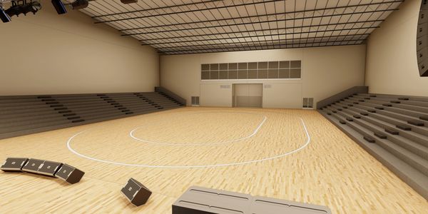 Empty indoor basketball court with wooden floor and seating stands.