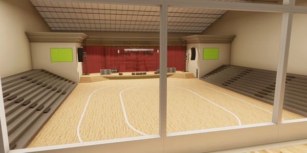 Empty indoor basketball court with bleachers and a stage.