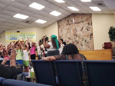 Children singing or performing in a church with audience.