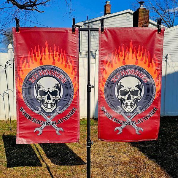 Two red flags with skulls, wrenches, and flames, reading '217 Hobbies, Work Sucks! Play Hard!'