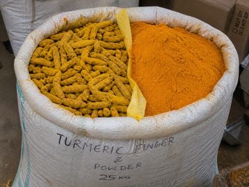 A large sack filled with turmeric roots and turmeric powder.