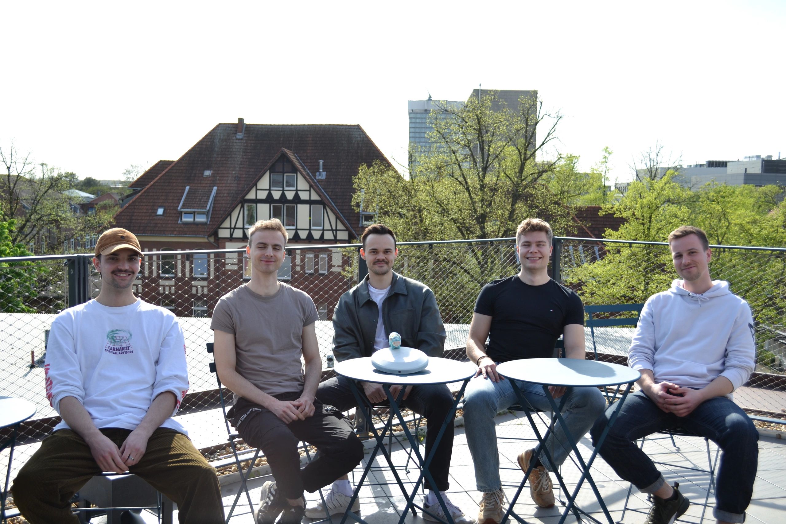 Group photo of the team behind DOORA on a roof top. The device DOORA on the table.