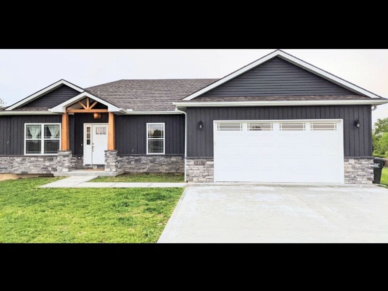 Modern single-story house with gray siding and stone accents.