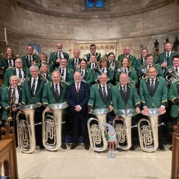 A group photo of a band with brass instruments inside a church.