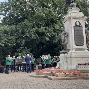 Band performing at a memorial monument outdoors.
