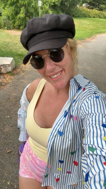 Woman smiling outdoors in casual summer attire.