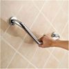 Hand gripping a chrome grab bar mounted on tiled wall.
