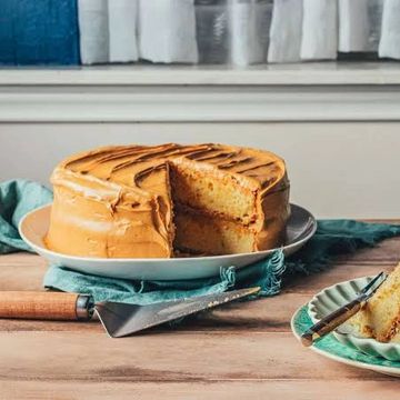 Caramel frosted layered cake with a slice cut out.